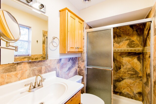 bathroom featuring tile walls, an enclosed shower, vanity, and toilet