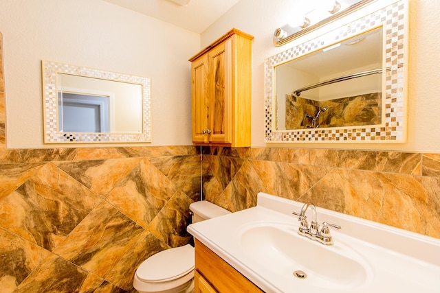 bathroom with vanity, toilet, tile walls, and a shower