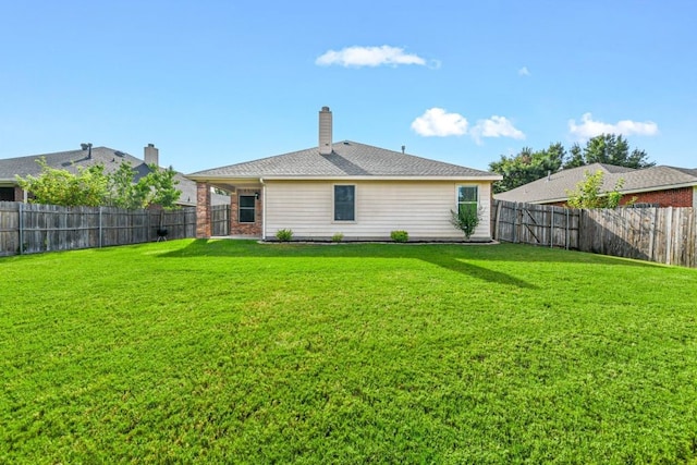 rear view of property featuring a yard