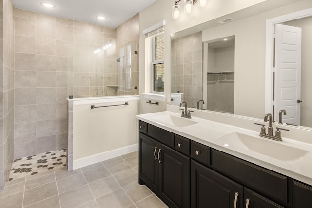 bathroom with tile patterned floors, vanity, and tiled shower