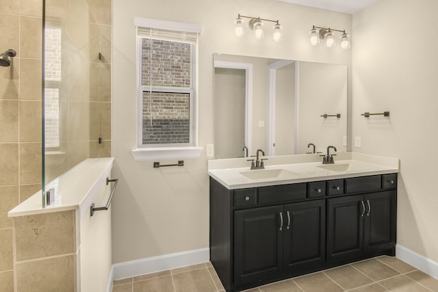 bathroom with tile patterned flooring, vanity, and tiled shower