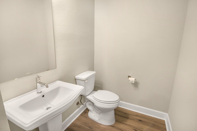 bathroom featuring hardwood / wood-style flooring, sink, and toilet