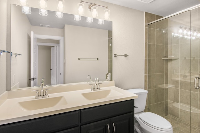 bathroom with an enclosed shower, vanity, and toilet