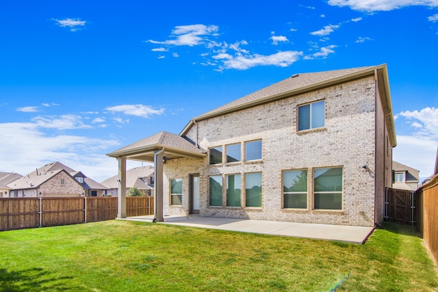 rear view of property with a lawn and a patio area