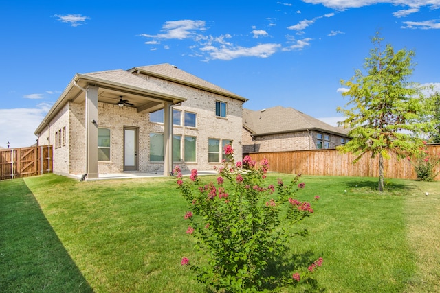 rear view of house with a yard, ceiling fan, and a patio area