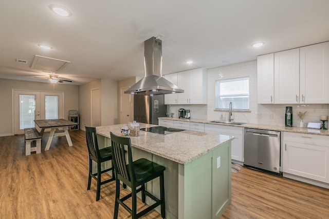 kitchen featuring island range hood, a kitchen island, stainless steel dishwasher, white cabinetry, and a sink