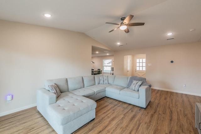 living room featuring lofted ceiling, a ceiling fan, baseboards, and wood finished floors