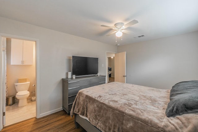 bedroom with ceiling fan, ensuite bathroom, visible vents, baseboards, and dark wood-style floors