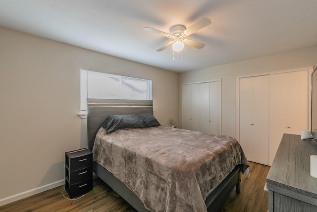 bedroom featuring a ceiling fan, dark wood-style flooring, baseboards, and two closets