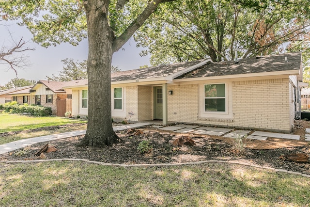 ranch-style home featuring a front yard, a patio area, and brick siding