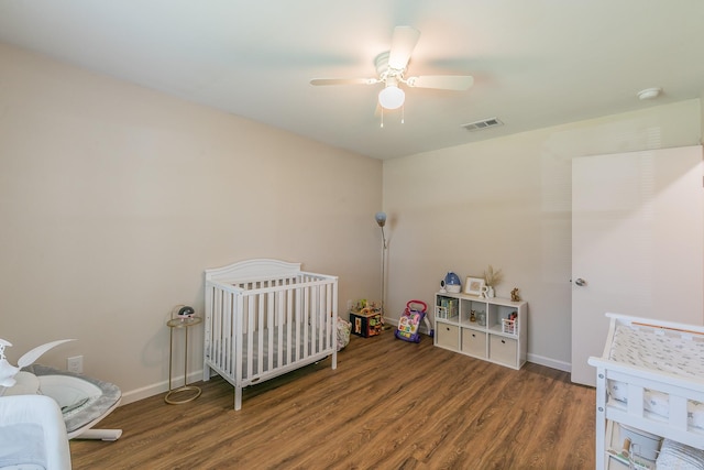 bedroom with visible vents, dark wood-type flooring, a ceiling fan, and baseboards