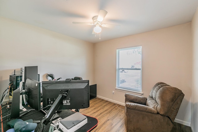 office space with a ceiling fan, light wood-style flooring, and baseboards