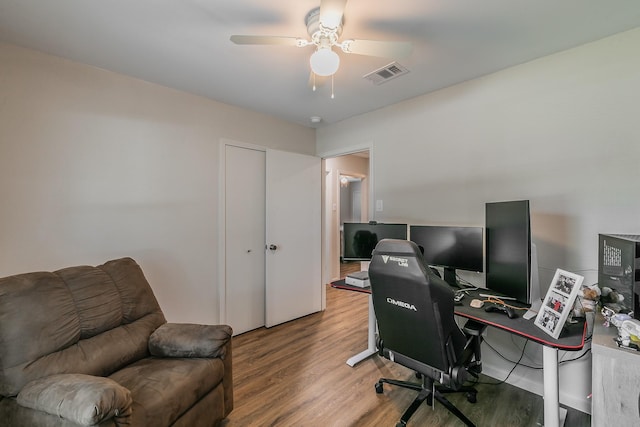 office featuring ceiling fan, wood finished floors, and visible vents