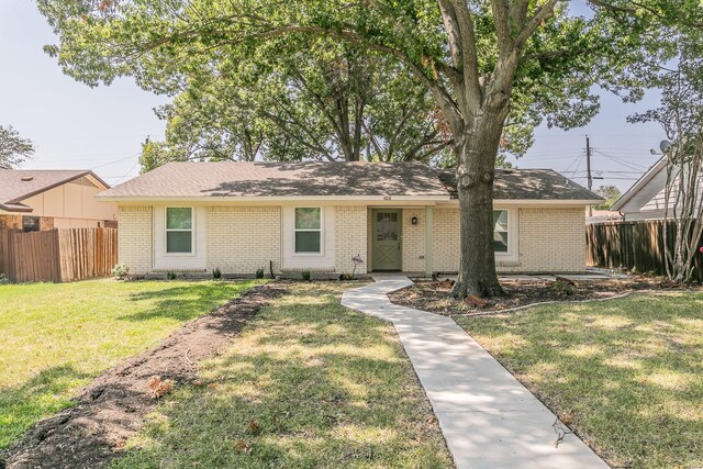 ranch-style home with fence, a front lawn, and brick siding