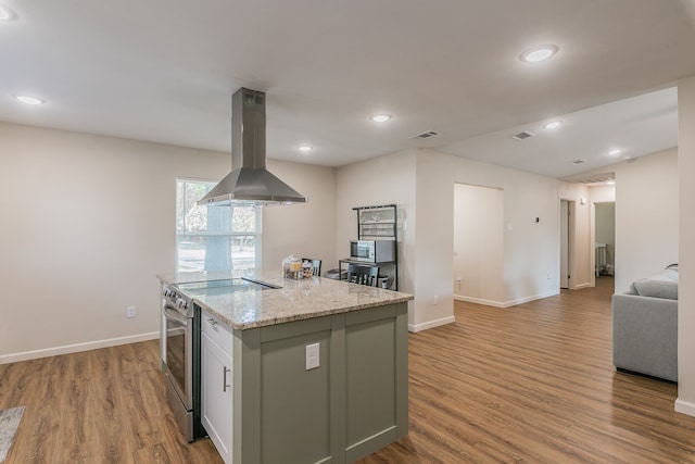 kitchen with island exhaust hood, stainless steel appliances, open floor plan, a kitchen island, and light wood-type flooring