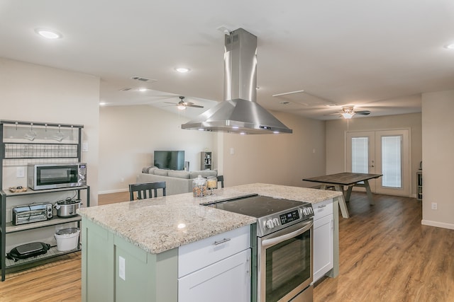 kitchen with island range hood, stainless steel appliances, a kitchen island, white cabinets, and light wood finished floors