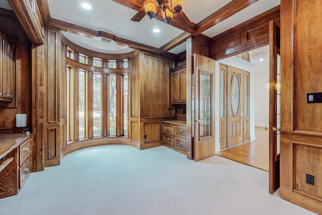 office space featuring ornamental molding, wood walls, and light colored carpet