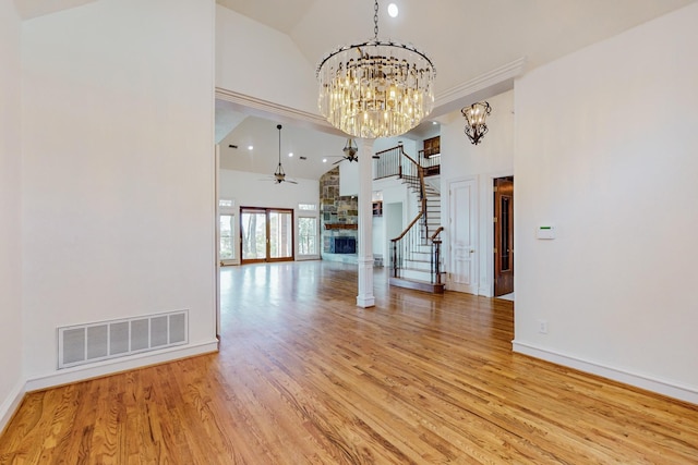 interior space with a fireplace, high vaulted ceiling, light hardwood / wood-style flooring, and ceiling fan