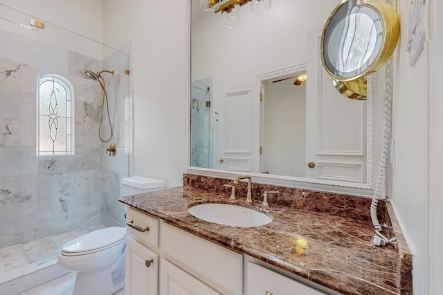 bathroom featuring vanity, toilet, and a shower with door