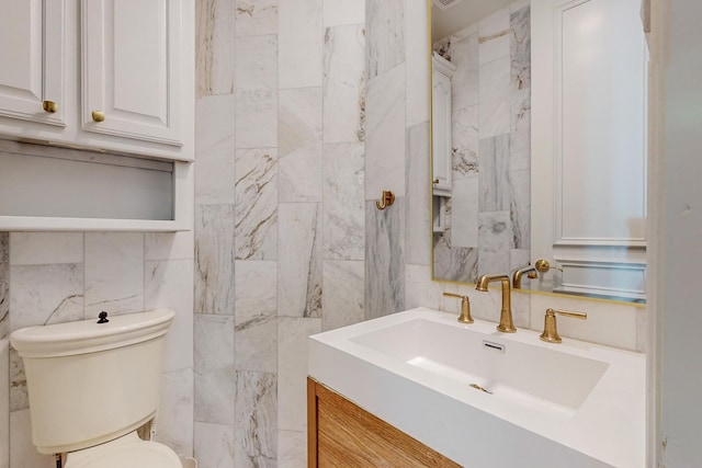 bathroom featuring vanity, tile walls, and toilet