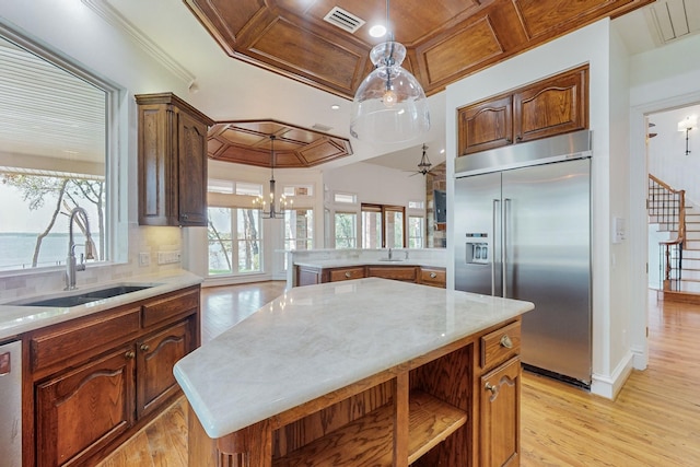 kitchen with a kitchen island, a wealth of natural light, sink, and stainless steel appliances