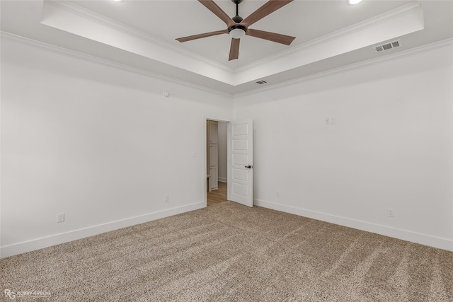 carpeted empty room with ornamental molding and a tray ceiling