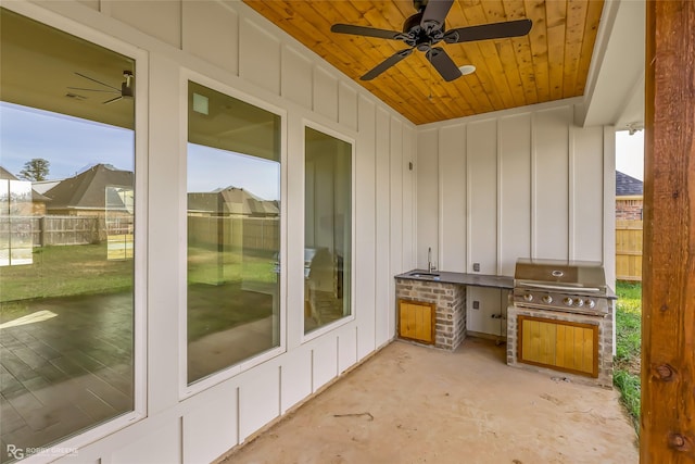 view of patio / terrace with ceiling fan, a grill, and exterior kitchen