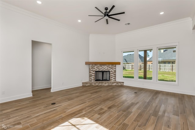 unfurnished living room with a fireplace, ceiling fan, crown molding, and hardwood / wood-style floors