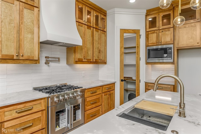 kitchen featuring custom exhaust hood, built in microwave, decorative backsplash, high end stove, and sink