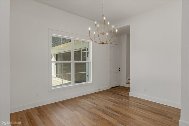 kitchen featuring white cabinetry, a fireplace, stainless steel appliances, an inviting chandelier, and sink