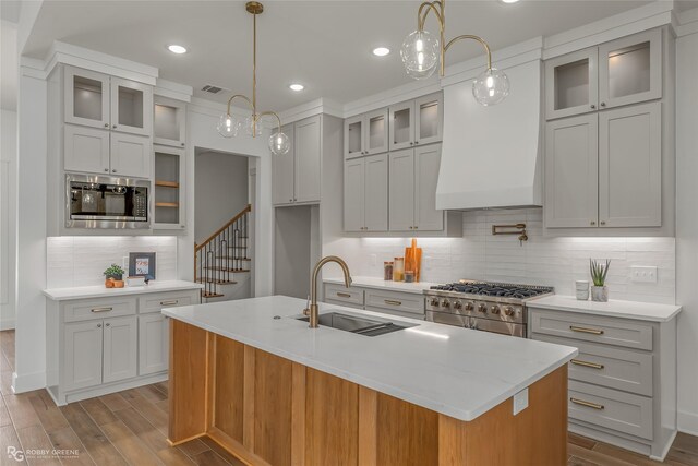 kitchen featuring range with two ovens, white cabinetry, custom exhaust hood, and a barn door