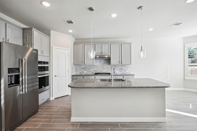 kitchen with gray cabinets, sink, an island with sink, and appliances with stainless steel finishes