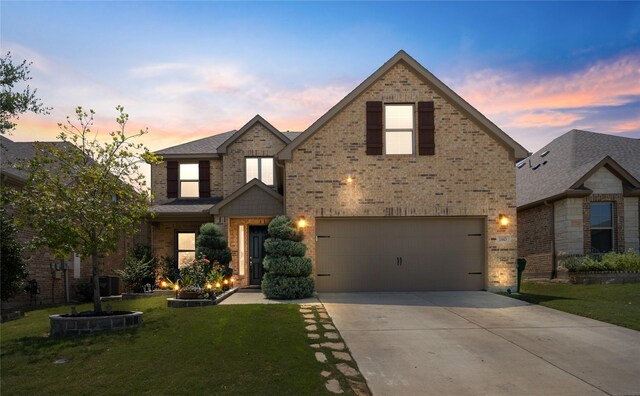 view of front of home featuring a lawn, central AC unit, and a garage