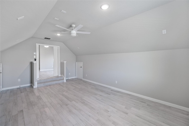 bonus room featuring ceiling fan, light hardwood / wood-style floors, a textured ceiling, and vaulted ceiling