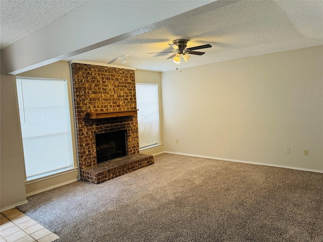 unfurnished living room featuring ceiling fan, a fireplace, a textured ceiling, and carpet