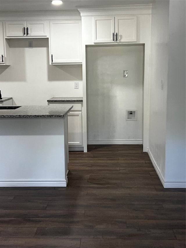 kitchen featuring stone counters, dark hardwood / wood-style floors, and white cabinetry