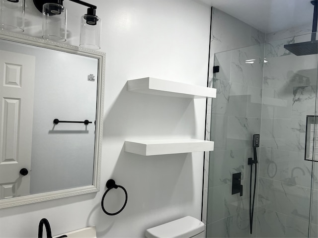 bathroom featuring a shower with door and toilet