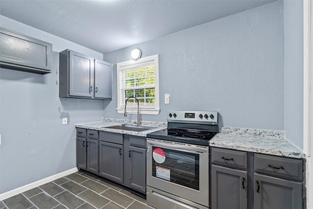 kitchen featuring gray cabinetry, stainless steel electric stove, and sink