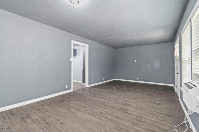 unfurnished room with baseboards and wood finished floors