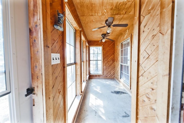 unfurnished sunroom featuring wood ceiling and ceiling fan