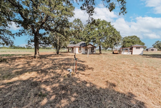 view of yard featuring a rural view and an outdoor structure