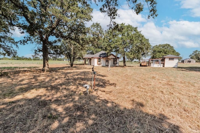 view of yard with a rural view and a storage unit