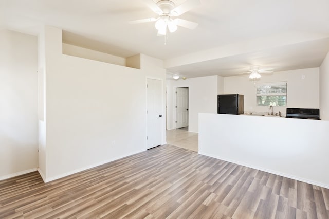 interior space with light hardwood / wood-style flooring, sink, and ceiling fan