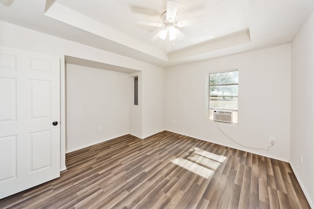 spare room featuring ceiling fan, a tray ceiling, dark hardwood / wood-style floors, and cooling unit