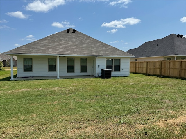 back of house with cooling unit and a lawn