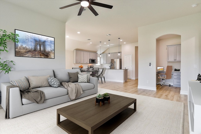 living room featuring light hardwood / wood-style flooring and ceiling fan