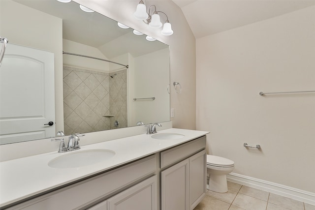 bathroom with dual vanity, tile patterned floors, lofted ceiling, and toilet