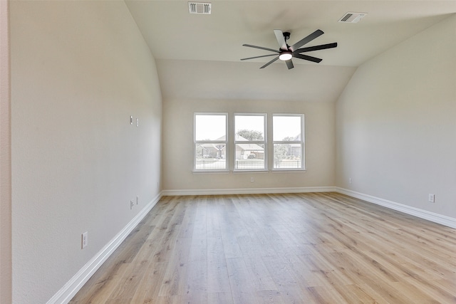 empty room with ceiling fan, lofted ceiling, and light hardwood / wood-style floors