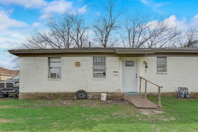 rear view of house featuring cooling unit and a lawn