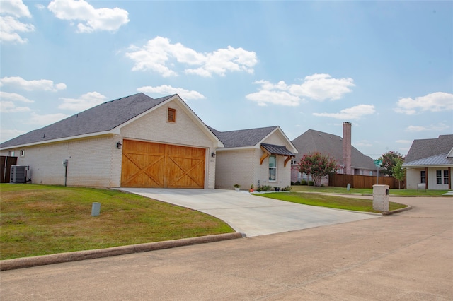 view of front of house featuring a garage, cooling unit, and a front lawn